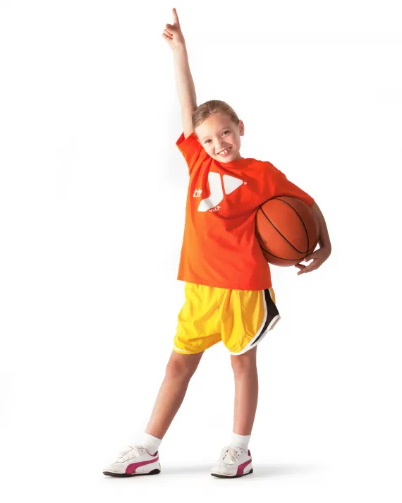 A girl holding a basketball and posing.