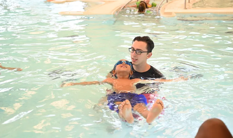 a boy floating with instructor assistance