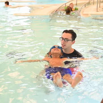 a boy floating with instructor assistance