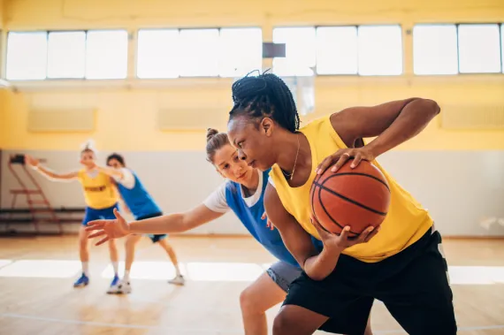 A group of people playing basketball.