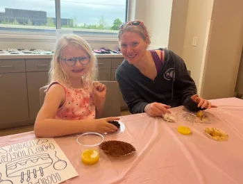 A mom and her daughter enjoying muffins and orange juice at our 2023 Muffins w/ Mom event!