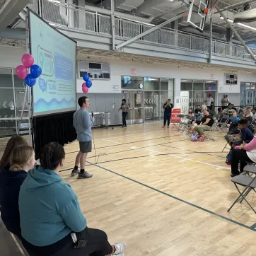 Our Director of Aquatics, Will K., speaking to a crowd at our JJ Swims Event.